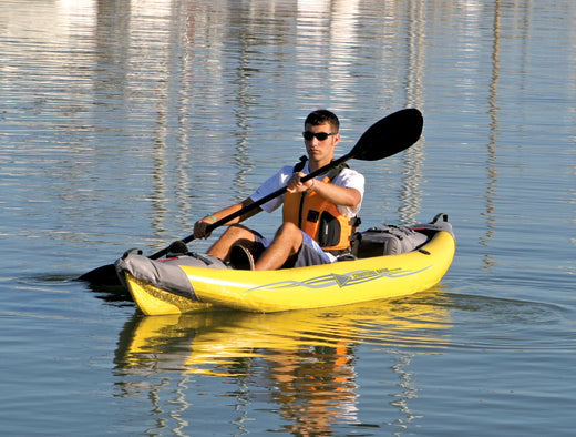 man paddling inflatable kayak