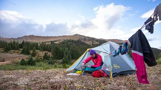 Person preparing a meal in a camping tent