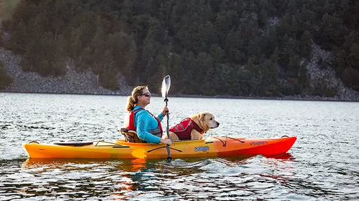 woman kayaking with her dog in doggie lifejacket