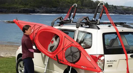 woman loading a kayak onto a roof rack with load assist system