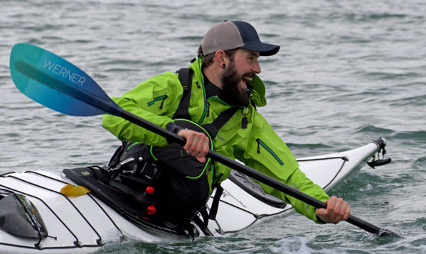 man smiling while paddling a kayak