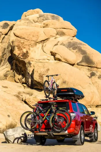 bike racks on a SUV parked in front of rocks