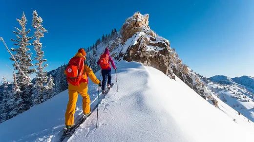 Two people walking in snow with snow gear
