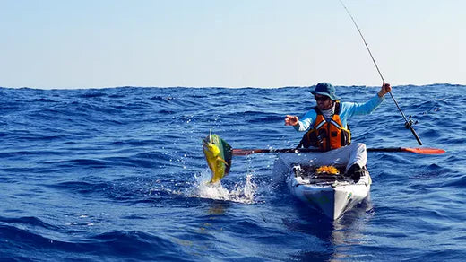 Person catching a fish on a kayak in the ocean