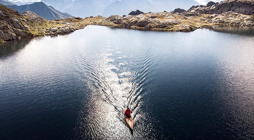 aerial view of a kayaker paddling on an alpine lake