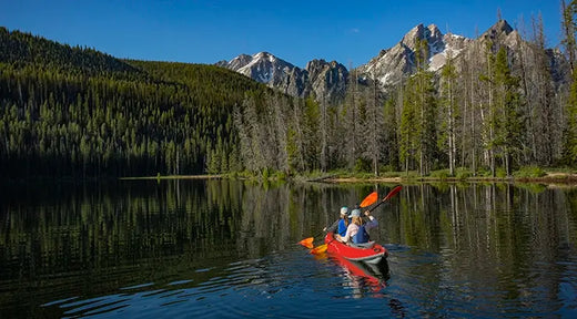 couple paddling a tandem kayak on a lake