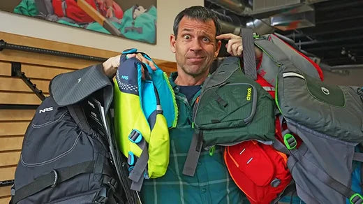 Ken Whiting looking confused holding many different lifejackets