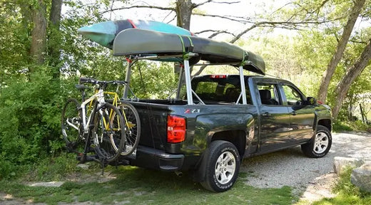 two kayaks loaded on a truck bed rack