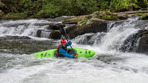 kayaker turning sharply next to river rapids