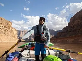 Man rowing raft filled with gear