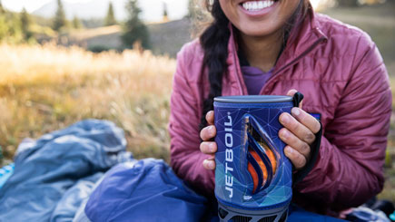 Woman smiling and holding Jetboil camp stove