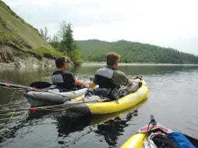 two men sitting in kayaks on the water
