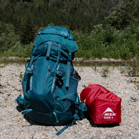 MSR Elixir 4 Person Backpacking Tent next to a backpack
