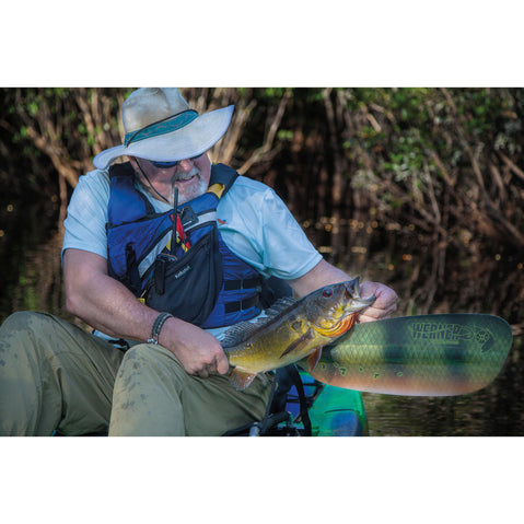 Fisherman holding fish next to paddle blade
