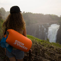 Woman looking at a waterfall with an IceMule Classic Cooler over her shoulder