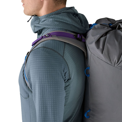 Patagonia Men's R1 Pullover Hoody close up of model wearing a backpack side view