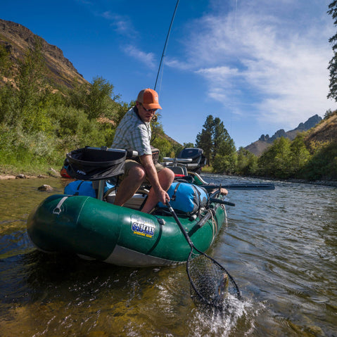 Outcast PAC 1300 Self-Bailing Raft  angler catching a fish
