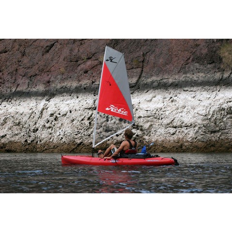 Hobie Mirage Kayak Sail Kit paddled solo by a rocky shore