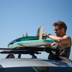 Yakima CrossBar Pads with person strapping down boards