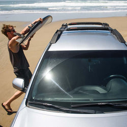 Yakima CrossBar Pads with person loading a board