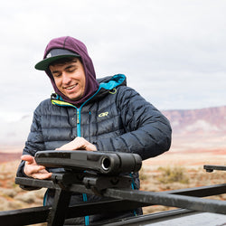 Kuat Class 4 Folding J Cradle Roof Rack Kayak Carrier folded by a kayaker